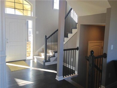 Entry with wood flooring and rod iron spindles.
