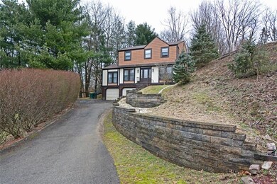 Curved stone retaining walls line the driveway.