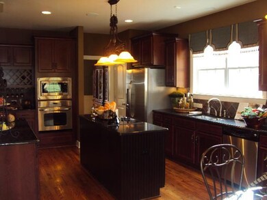 Gourmet kitchen with island cooktop, abundance of cabinets, built-in desk too!! (Photo of Decorated Model & For Representation Only)