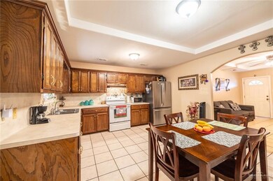 Kitchen featuring tasteful backsplash, sink, stainless steel appliances, and a tray ceiling