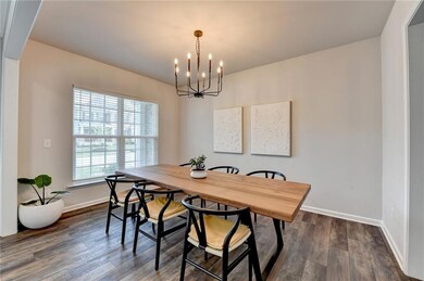 Dining space featuring a chandelier, baseboards, and dark wood finished floors