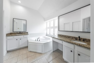 The primary bathroom in this exquisite home is a luxurious retreat, featuring dual separate sinks and a lavish jetted tub. The thoughtful design and upscale amenities create a spa-like atmosphere that exudes comfort and sophistication.