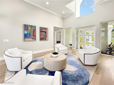 Living area with crown molding, a towering ceiling