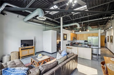 Living area with concrete floors, a high ceiling, and a ceiling fan