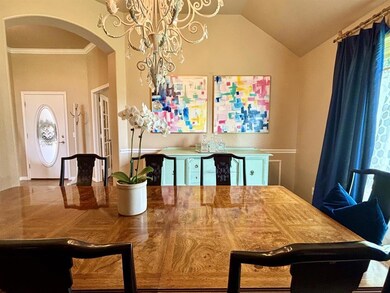 Dining space with arched walkways, a chandelier, lofted ceiling, and ornamental molding