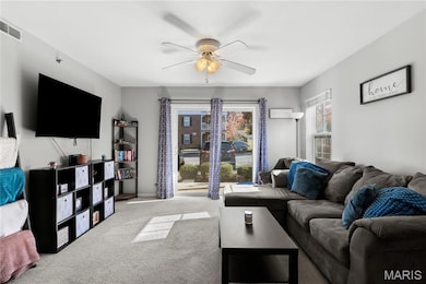 Carpeted living room with a ceiling fan