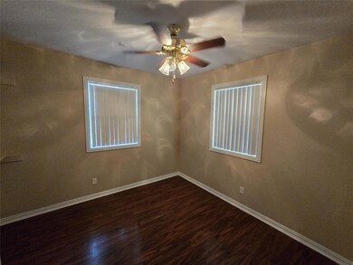 Unfurnished room featuring ceiling fan and hardwoo