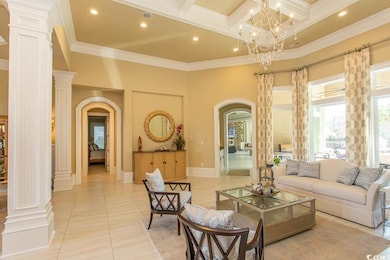 Living area featuring ornamental molding, light tile patterned floors, decorative columns, a high ceiling, and arched walkways