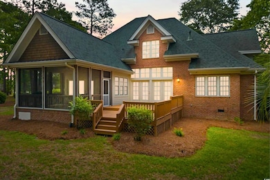 Back of property at dusk featuring roof with shing
