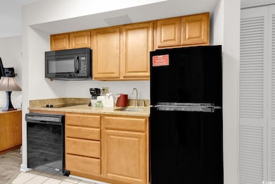 Kitchen with light tile patterned floors, light st