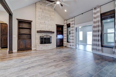 living room with a stone fireplace, ceiling fan, h