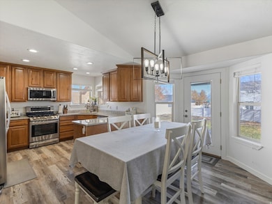 Dining room featuring light wood-type flooring, recessed lighting, a chandelier, and lofted ceiling