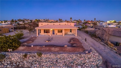 View of front of property with stucco siding, a patio, fence, and a tiled roof