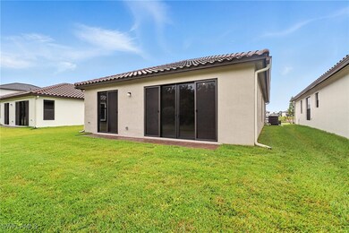 Rear view of property featuring a lawn and stucco