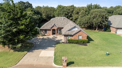 View of front of property with driveway, brick siding, and a front yard