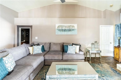 Living room featuring baseboards, lofted ceiling, 