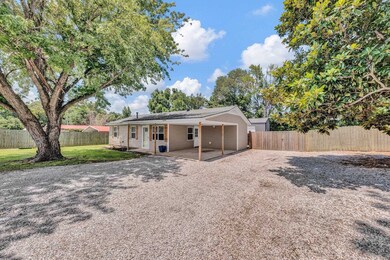 Rear view of property featuring driveway and a fenced backyard