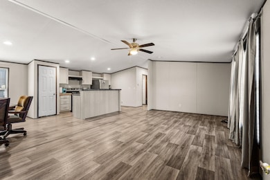 Living area with light wood finished floors, lofted ceiling, ceiling fan, a desk, and recessed lighting