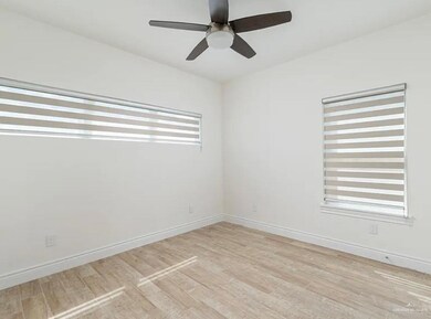Empty room with light wood-style flooring, baseboards, and ceiling fan