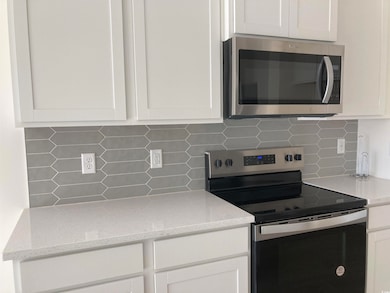 Kitchen featuring decorative backsplash, white cab