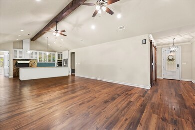 High ceilings with a large wooden beam across the length of the kitchen & living area