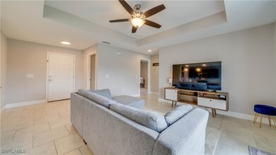 Living room featuring a ceiling fan, light tile pa