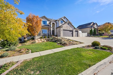 Traditional-style home featuring driveway, stucco siding, and stone siding