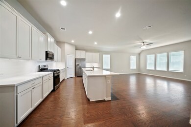 The fantastic open kitchen is light and bright and features light cabinets, a walk-in pantry and an oversized Island.