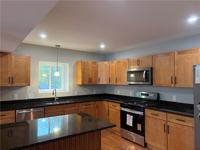 Beautiful kitchen with island, granite countertops, and recessed lighting.