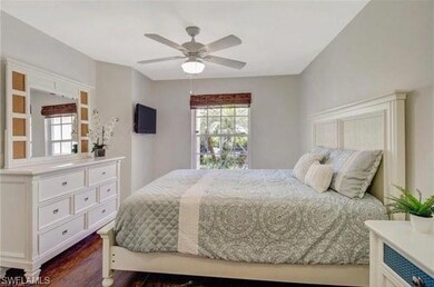 Bedroom with ceiling fan and dark hardwood / wood-