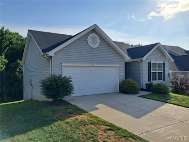 Ranch-style home with an attached garage, concrete driveway, and a front yard