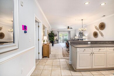 Kitchen with a chandelier, ornamental molding, ceiling fan, light tile patterned floors, and open floor plan