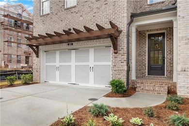 Entrance to property with brick siding, driveway, and an attached garage