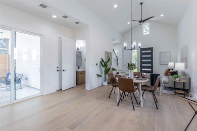 Dining area with light wood-style flooring, high vaulted ceiling, and recessed lighting