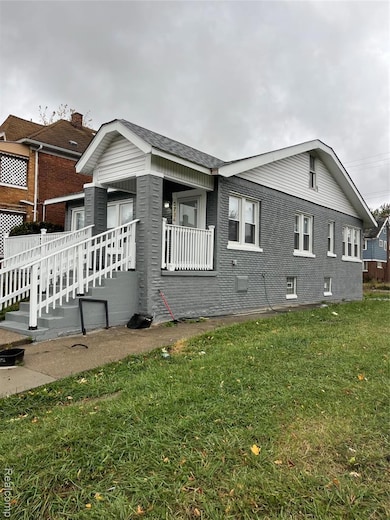 View of side of property with a lawn, brick siding, and roof with shingles