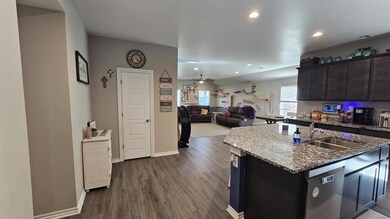 Kitchen featuring stainless steel dishwasher, ceiling fan, dark wood-style flooring, stone counters, and recessed lighting