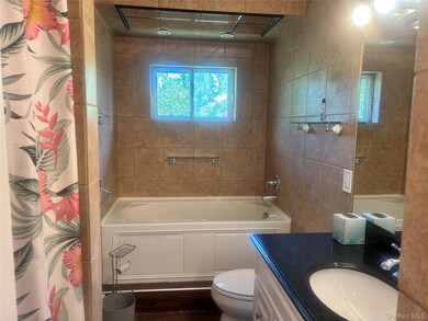Bathroom with vanity, plenty of natural light, and a combined bath / shower with rainfall shower