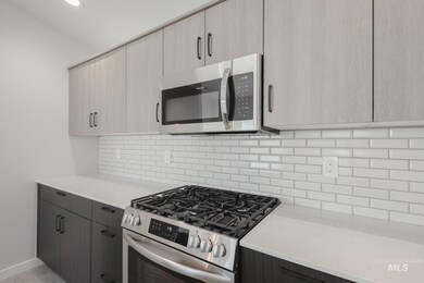 Kitchen with stainless steel appliances, backsplash, light stone counters, modern cabinets, and recessed lighting