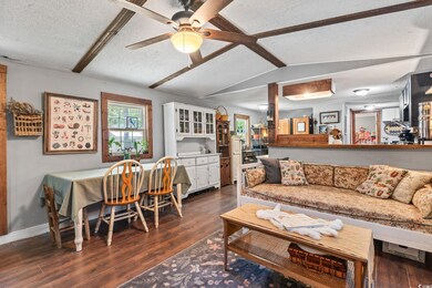 Living area featuring dark wood finished floors, ceiling fan, and a textured ceiling