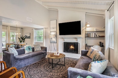 Living room with a chandelier, a fireplace, and wooden ceiling
