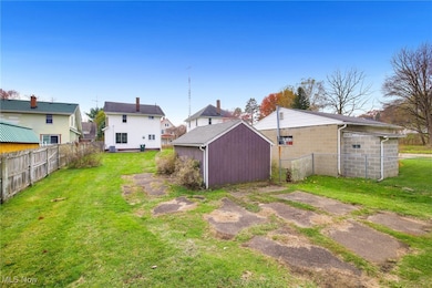 Fenced backyard featuring an outbuilding