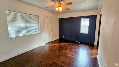 Unfurnished bedroom featuring dark wood-style flooring and ceiling fan