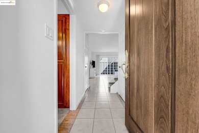 Hallway with light tile patterned floors and baseboards