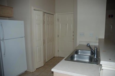 Kitchen with freestanding refrigerator, a sink, l