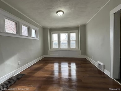 Unfurnished room featuring dark wood finished floors and crown molding