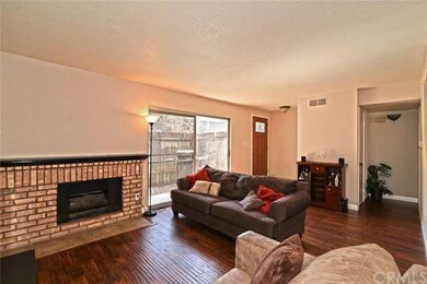 VIEW OF LIVING ROOM SHOWCASING BRICK FIREPLACE AND