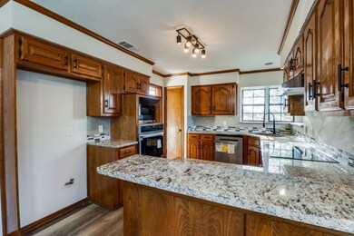 Kitchen featuring brown cabinetry, ornamental mold