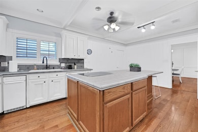 Bright kitchen with wood flooring, featuring white