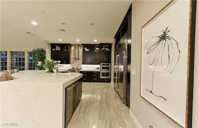 Kitchen featuring wall chimney range hood, stainle