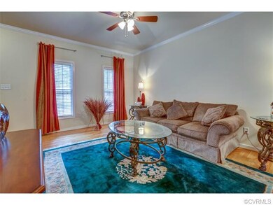 Living room with hardwood floors, and crown mouldi